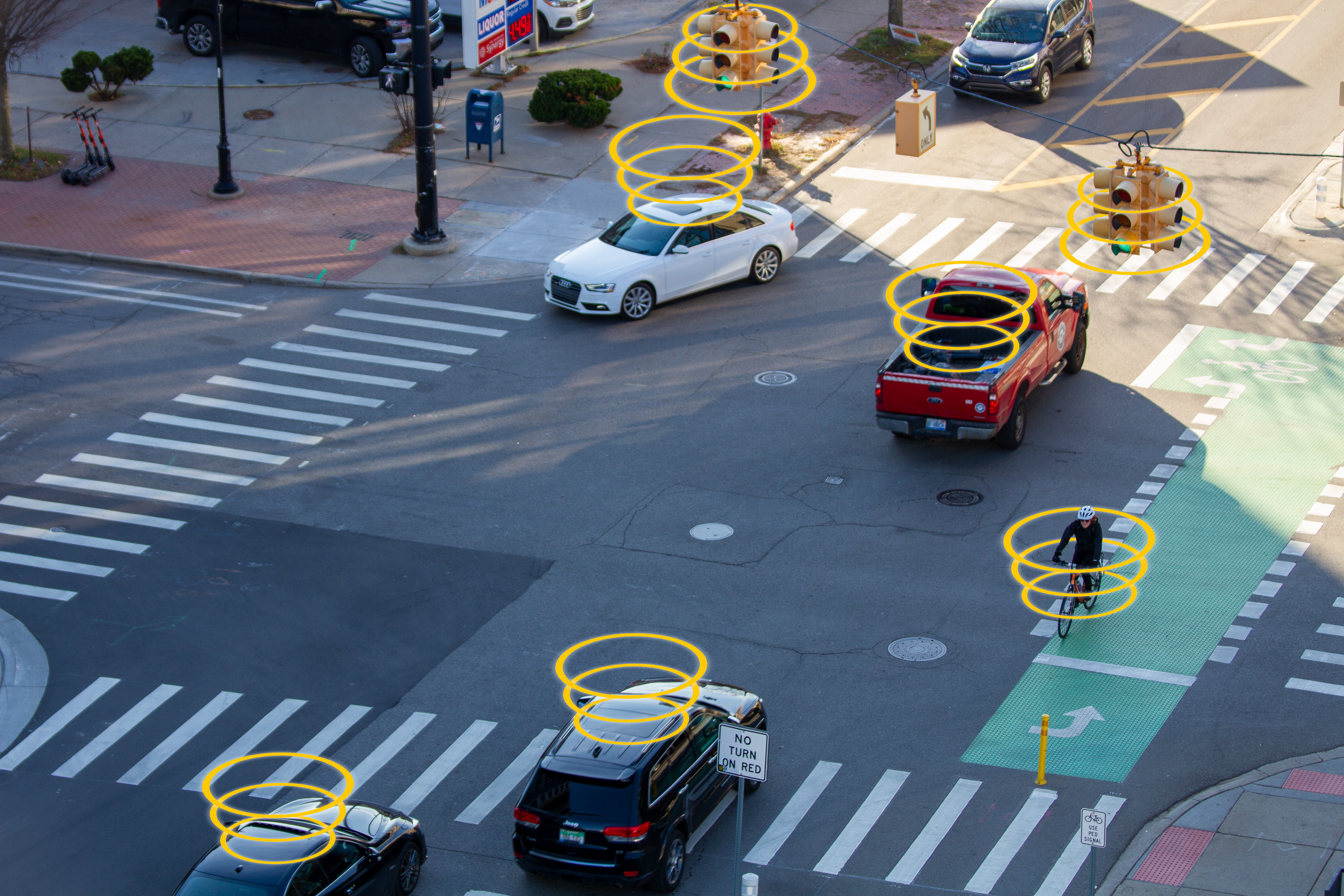 Aerial photo of an intersection in Ann Arbor with vehicles and bicyclists moving through it 