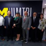 USDOT and UMTRI Leadership stand in front of UMTRI sign