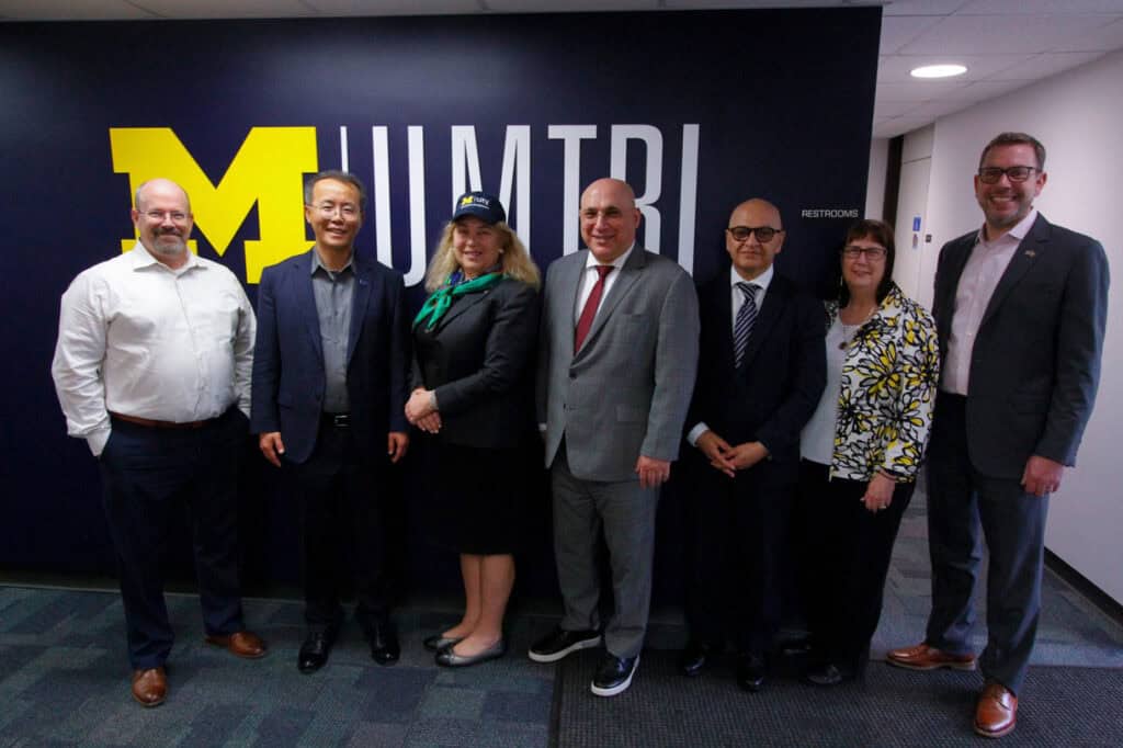 USDOT and UMTRI Leadership stand in front of UMTRI sign